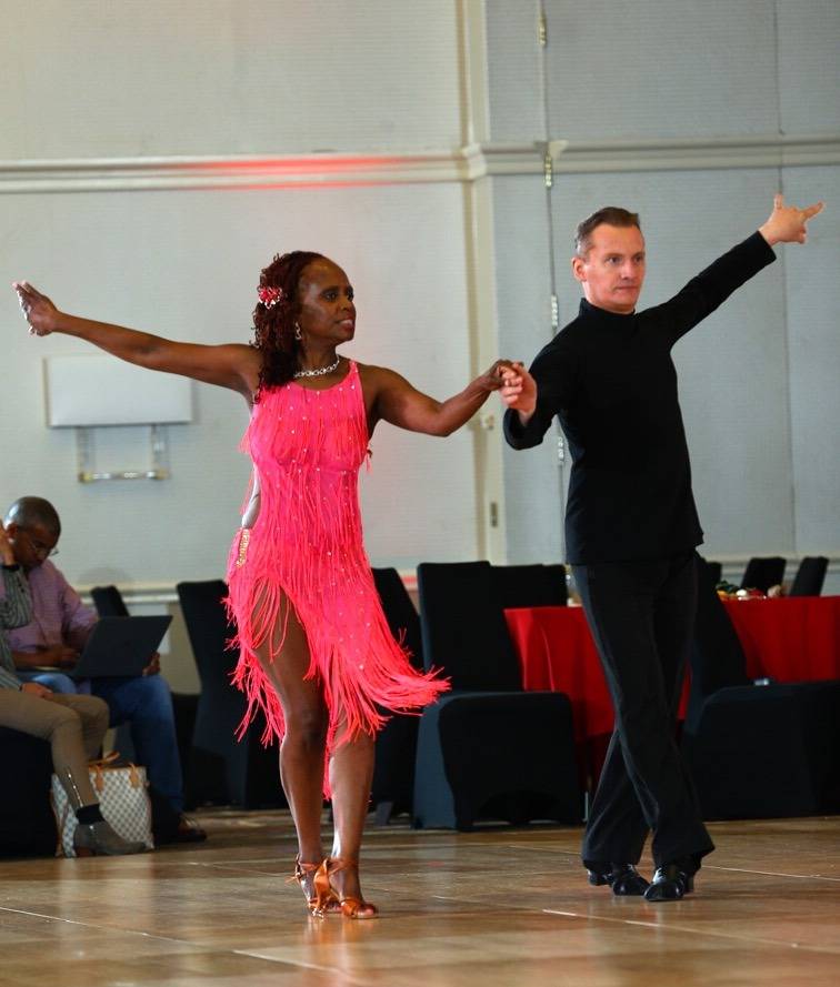 Denis dancing with dance student at dance competition